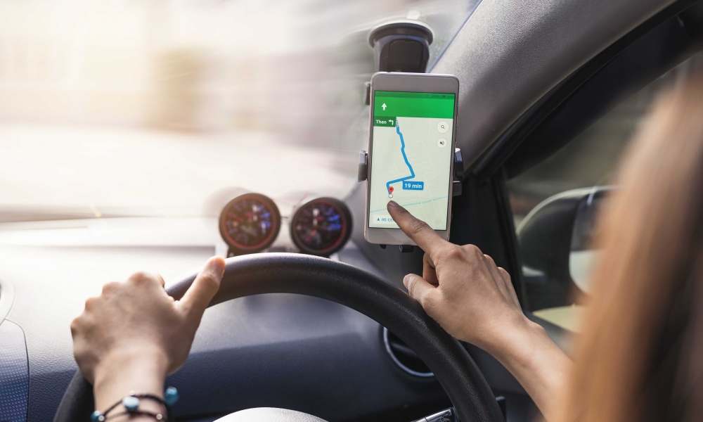 woman using gps navigation map on smartphone in car